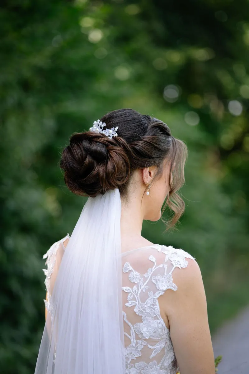 Brautfrisur von hinten: eingedrehter Chignon mit Perlenkamm und Schleier – DK Beauty Lounge Bodelshausen
